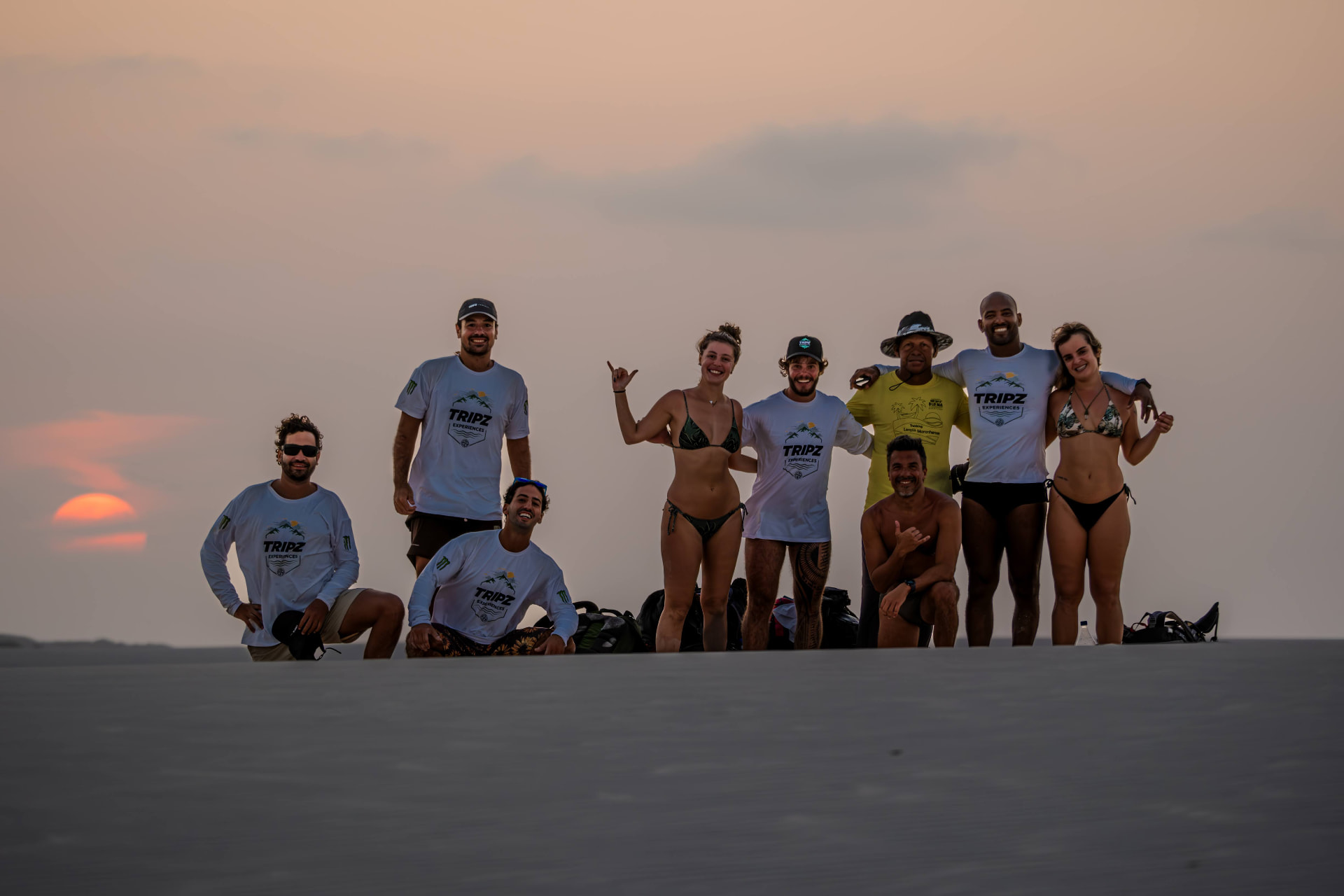 Grupo de viajantes da Tripz em dunas ao pôr do sol nos Lençóis Maranhenses